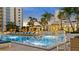 Luxurious swimming pool surrounded by seating areas with umbrellas and palm trees at 100 1St N Ave # 1005, St Petersburg, FL 33701