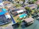 A stunning aerial view highlights a waterfront home with pool, dock and solar panels at 1012 Spindle Palm Way, Apollo Beach, FL 33572