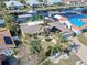 This aerial view features a waterfront home with solar panels, brick driveway, lush landscaping, and canal access at 1012 Spindle Palm Way, Apollo Beach, FL 33572