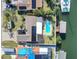 An overhead view showcases a waterfront home with a private pool, boat dock, solar panels and brick driveway at 1012 Spindle Palm Way, Apollo Beach, FL 33572