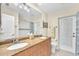 Bright bathroom featuring a granite countertop with double sinks and a door leading outside at 1012 Spindle Palm Way, Apollo Beach, FL 33572