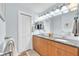Well-lit bathroom with double sinks, wood cabinets, and a neutral color scheme at 1012 Spindle Palm Way, Apollo Beach, FL 33572