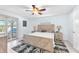 Serene bedroom with a modern wooden bed frame, ceiling fan, and sliding glass door to the outside at 1012 Spindle Palm Way, Apollo Beach, FL 33572