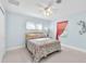 Cozy bedroom with light blue walls, ceiling fan, and colorful sea-themed bedding at 1012 Spindle Palm Way, Apollo Beach, FL 33572