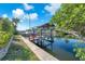 Canal-front home featuring a private boat dock with a boat lift along a waterway with tropical landscaping at 1012 Spindle Palm Way, Apollo Beach, FL 33572