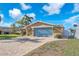 Charming home featuring a spacious blue garage door, neutral paint color, and a patterned brick drive at 1012 Spindle Palm Way, Apollo Beach, FL 33572