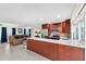 Modern kitchen flowing into the living area, complete with a stainless steel refrigerator and island at 1012 Spindle Palm Way, Apollo Beach, FL 33572