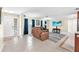Bright living room with tile flooring, blue curtains, a large sectional couch, and a flat screen television at 1012 Spindle Palm Way, Apollo Beach, FL 33572
