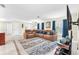 Open-concept living room featuring tile flooring, modern decor, and comfortable seating with a flat screen television at 1012 Spindle Palm Way, Apollo Beach, FL 33572