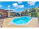 Backyard with a sparkling pool, hot tub, and a lounge area under a wooden pergola at 1012 Spindle Palm Way, Apollo Beach, FL 33572