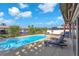 A refreshing backyard pool is surrounded by lounge chairs for relaxation and canal views at 1012 Spindle Palm Way, Apollo Beach, FL 33572