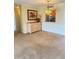 Dining area with neutral carpet flooring, decorative light fixture, and view of the kitchen through a pass-through window at 10316 Carrollwood Ct # 57, Tampa, FL 33618