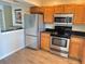 Modern kitchen featuring stainless steel appliances and wooden cabinetry and wood-look floors at 10316 Carrollwood Ct # 57, Tampa, FL 33618