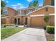Inviting two-story townhome with an attached two-car garage, manicured lawn, and walkway leading to the front door at 10849 Kensington Park Ave, Riverview, FL 33578