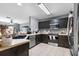 Well-lit kitchen featuring dark cabinetry, modern stainless steel appliances, and ample counter space at 10849 Kensington Park Ave, Riverview, FL 33578