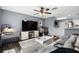 Comfortable living room featuring a large TV, ceiling fan, and open access to the kitchen area at 10849 Kensington Park Ave, Riverview, FL 33578