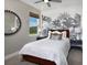 This bedroom has a wallpaper accent wall, large window, stylish light fixtures and neutral color palette at 11288 Boundless Ter, Venice, FL 34293