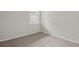 This bedroom has neutral walls and carpet and a bright window at 11290 Boundless Ter, Venice, FL 34293