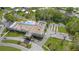 Aerial view of clubhouse with pool and bocce ball near roads and other homes on a sunny day at 11728 Carissa Ln # 0, New Port Richey, FL 34654