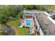 Aerial view of outdoor pool with lounge chairs surrounding it on a sunny day with a pond nearby at 11728 Carissa Ln # 0, New Port Richey, FL 34654