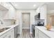 Well-lit kitchen featuring stainless steel appliances, ample countertop space, stylish backsplash, and modern white cabinetry at 1203 16Th Se Cir, Largo, FL 33771