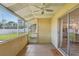 Screened patio with a view of the fenced backyard, exterior door, and sliding glass door to the kitchen at 1203 16Th Se Cir, Largo, FL 33771