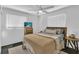 Bedroom with a ceiling fan, two windows, and a bed featuring a neutral-toned knit blanket at 129 Nw Lincoln N Cir, St Petersburg, FL 33702