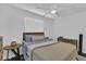 Bedroom with a ceiling fan, two windows, and a bed featuring a neutral-toned knit blanket at 129 Nw Lincoln N Cir, St Petersburg, FL 33702