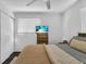 Bedroom with a television, a closet, and a comfortable bed featuring a neutral-toned knit blanket at 129 Nw Lincoln N Cir, St Petersburg, FL 33702