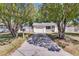 Charming single-story home with a neatly kept front yard, framed by mature trees and a private driveway at 129 Nw Lincoln N Cir, St Petersburg, FL 33702