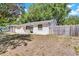 Quaint one story home with a side view, showcasing its well-maintained lawn and fenced yard at 129 Nw Lincoln N Cir, St Petersburg, FL 33702