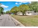 A home on a tree-lined street showcasing a neat lawn, mature trees, and an inviting curb appeal at 129 Nw Lincoln N Cir, St Petersburg, FL 33702