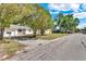 Street view of single-story house, featuring mature trees, well-kept lawn, and a paved driveway at 129 Nw Lincoln N Cir, St Petersburg, FL 33702