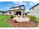 A manicured backyard features a paver patio with Adirondack chairs surrounded by lush landscaping at 13042 Pennybrook Dr, Riverview, FL 33579