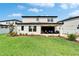 A backyard features a covered patio with lounge seating and an expansive lawn area at 13042 Pennybrook Dr, Riverview, FL 33579
