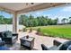 Backyard patio with outdoor furniture and an expansive lawn area surrounded by trees at 13042 Pennybrook Dr, Riverview, FL 33579