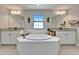 Bright bathroom featuring a large tub, double vanity with granite counter tops, and neutral tile flooring at 13042 Pennybrook Dr, Riverview, FL 33579