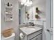 Charming bathroom with granite countertop, gray cabinetry, decorative shelves and neutral accents at 13042 Pennybrook Dr, Riverview, FL 33579