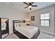 Bedroom featuring neutral decor with a large mirror, ceiling fan, and a view of the outside at 13042 Pennybrook Dr, Riverview, FL 33579
