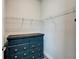 Organized walk-in closet with white wire shelving and blue dresser with dark wood top at 13042 Pennybrook Dr, Riverview, FL 33579
