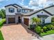 Charming two-story home featuring a lush landscaped yard and brick-paved driveway at 13042 Pennybrook Dr, Riverview, FL 33579
