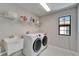 Laundry room showcasing modern washer and dryer, a sink, and shelf storage at 13042 Pennybrook Dr, Riverview, FL 33579