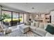 Open-concept living room featuring a large sectional sofa, sliding glass doors, and modern kitchen at 13042 Pennybrook Dr, Riverview, FL 33579