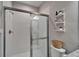 Modern bathroom featuring glass-enclosed shower and decorative shelving above the toilet at 13042 Pennybrook Dr, Riverview, FL 33579