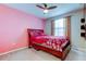 Bright bedroom with a ceiling fan, pink accent wall, and a comfortable bed at 13923 Arbor Pines Dr, Riverview, FL 33579