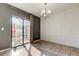 Bright dining room featuring decorative molding, gray accent wall, modern chandelier and sliding glass doors to the patio at 13923 Arbor Pines Dr, Riverview, FL 33579