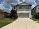 Inviting two-story home with a well-maintained lawn, concrete driveway, and attached garage at 13923 Arbor Pines Dr, Riverview, FL 33579