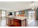 Open kitchen features a spacious island with sink and stainless steel dishwasher, overlooking the dining and living area at 13923 Arbor Pines Dr, Riverview, FL 33579