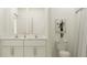 Bright bathroom featuring a double vanity with white cabinets, quartz countertops, and a framed mirror at 15238 Rainbow Quartz St, Wimauma, FL 33598