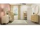 Charming Bedroom with a light wood crib, dresser, shelves, pink accent wall, and a patterned rug at 15238 Rainbow Quartz St, Wimauma, FL 33598